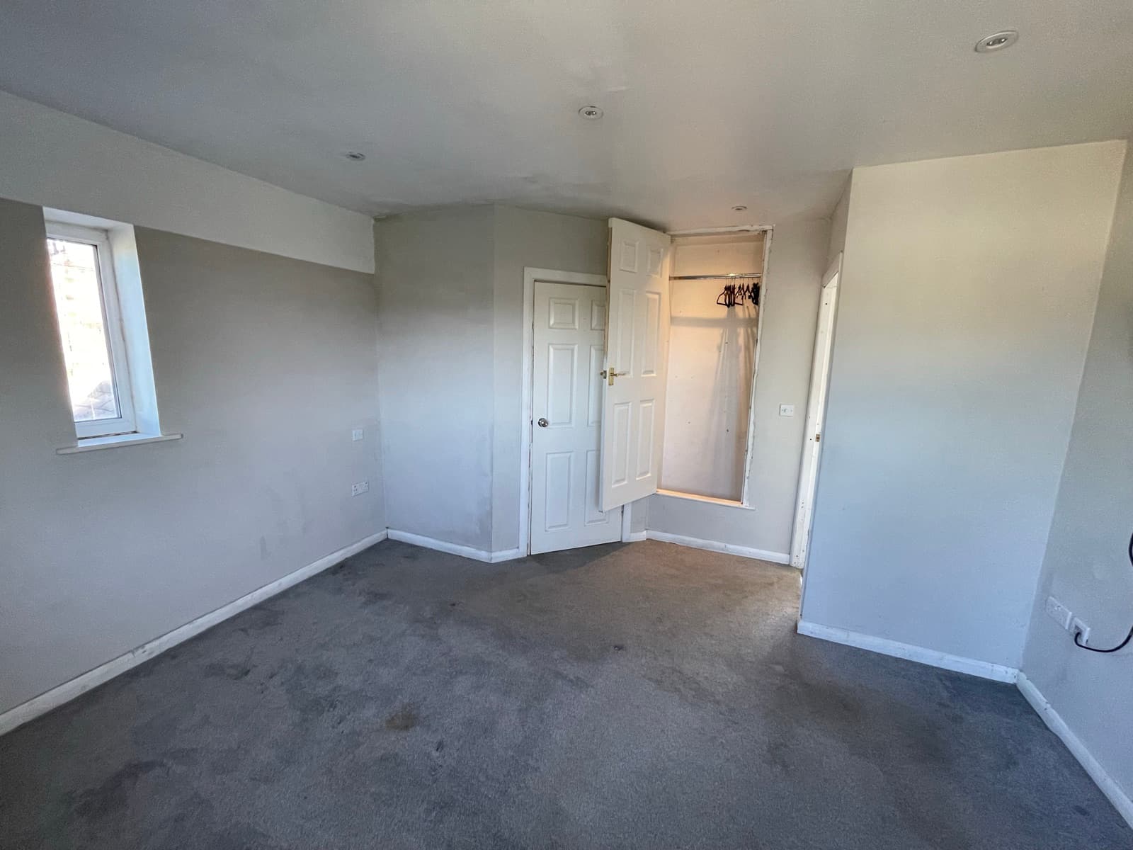 Master bedroom with window and storage cupboard